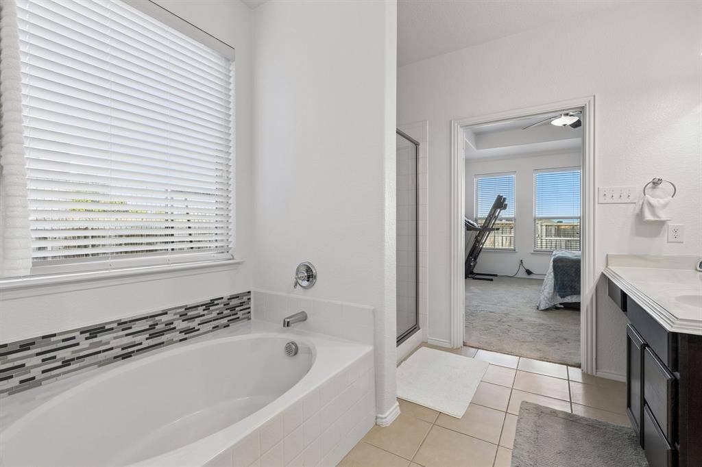 1501 Coyote Ridge Road, Wylie, TX 75098 Soaking tub with a mosaic tile surround and chrome fixtures