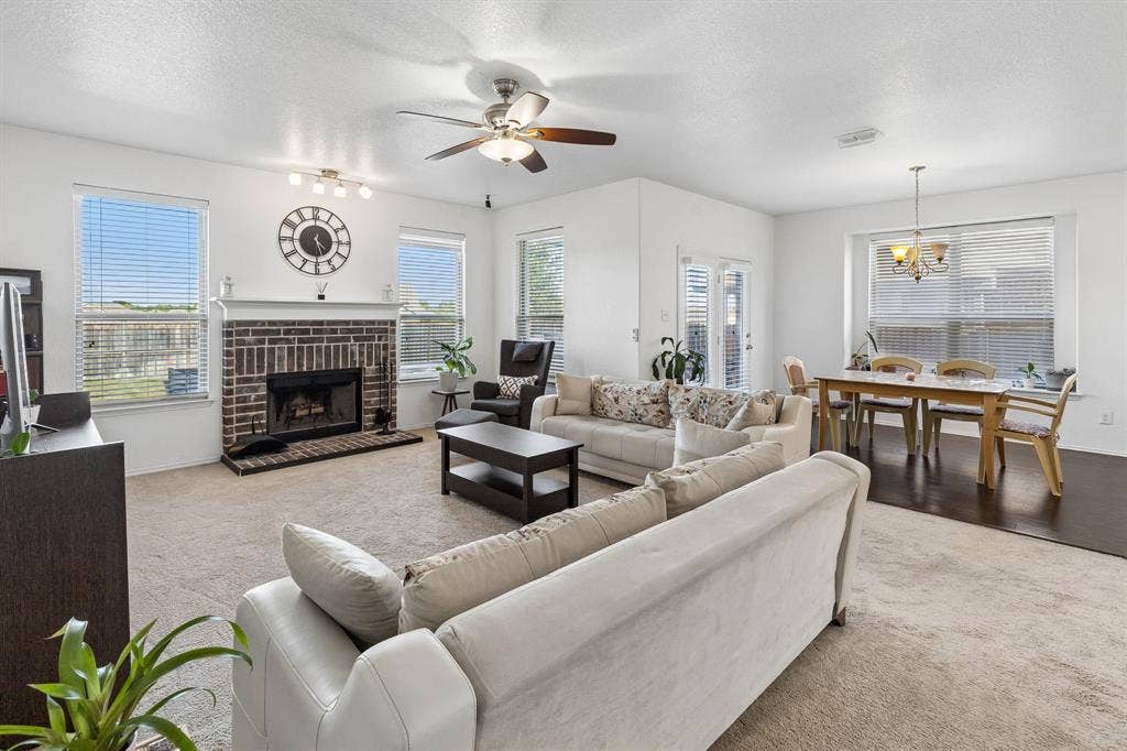 1501 Coyote Ridge Road, Wylie, TX 75098 Living area with a brick fireplace, white mantel, and ceiling fan