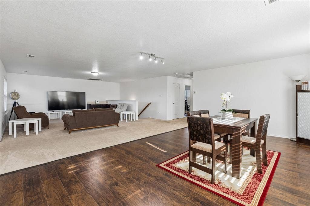 1501 Coyote Ridge Road, Wylie, TX 75098 Expansive open-concept living area featuring wood-finish flooring, recessed lighting, and a neutral color palette