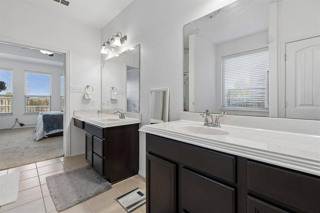 1501 Coyote Ridge Road, Wylie, TX 75098 Dual vanities with integrated sinks, dark wood-finish cabinetry, and tiled flooring