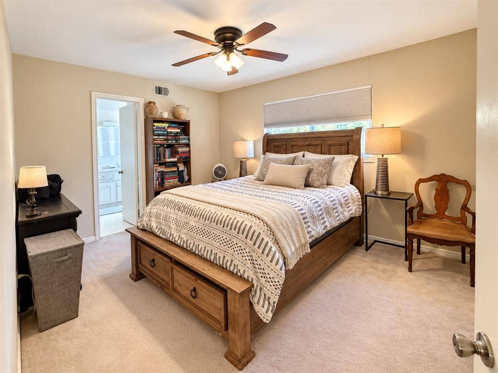 10734 Candlewood Drive, Houston, TX 77042 Carpeted bedroom featuring a ceiling fan, a window with roller shade, and a wood-finish bed frame with built-in storage