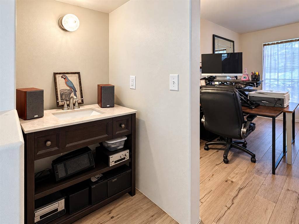 10734 Candlewood Drive, Houston, TX 77042 Dark wood-finish vanity with an undermount sink, light-toned countertop, and chrome faucet