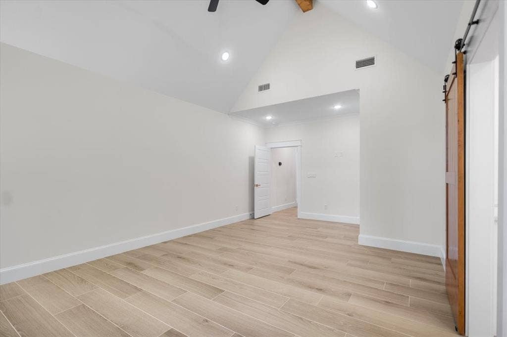13920 Cedar Hill, Tyler, TX 75704 Vaulted ceiling with exposed wood beam, wood-finish tile flooring, recessed lighting, and a barn door