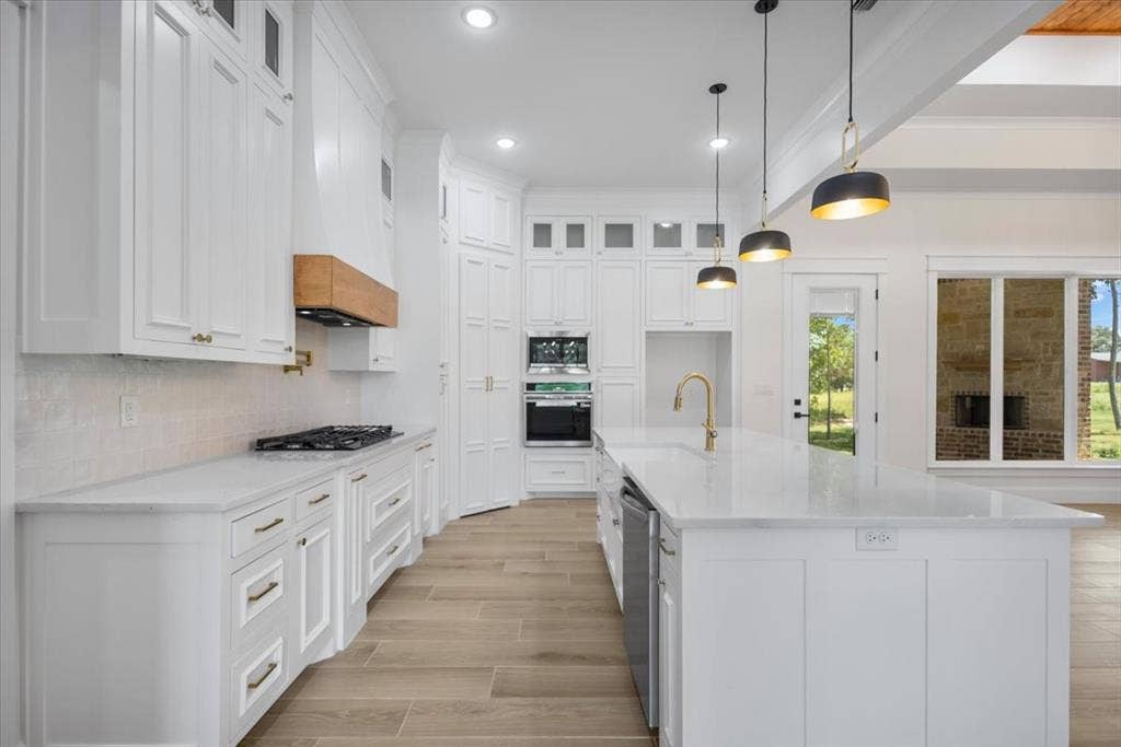 13920 Cedar Hill, Tyler, TX 75704 White shaker cabinetry, light-toned wood-finish flooring, white countertops, built-in double ovens, and a large central island