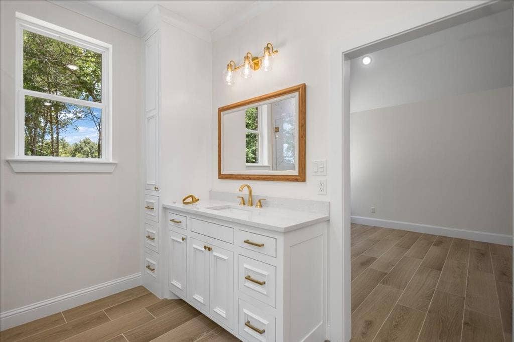 13920 Cedar Hill, Tyler, TX 75704 Single vanity with a white countertop and integrated sink, gold-finish faucet, and wood-framed mirror