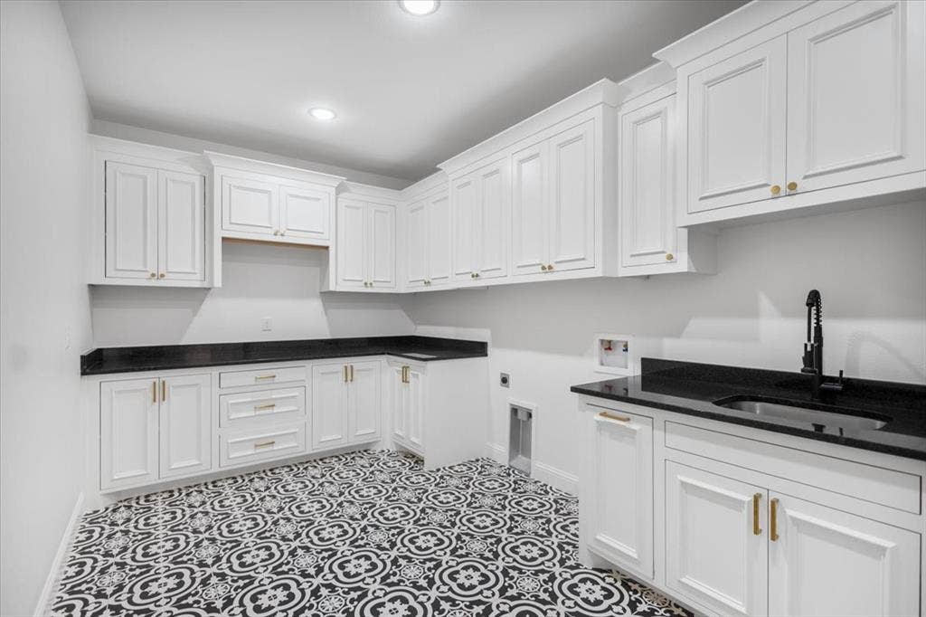 13920 Cedar Hill, Tyler, TX 75704 White shaker cabinetry, black countertops, patterned floor tiles, recessed lighting, and a black faucet with an undermount sink