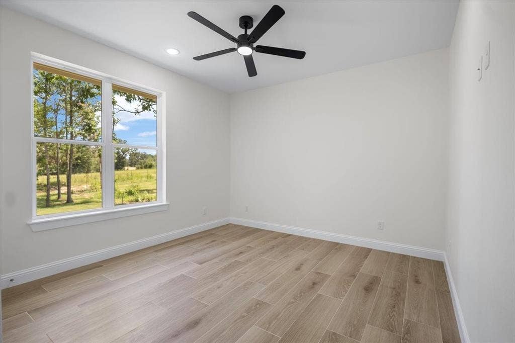 13920 Cedar Hill, Tyler, TX 75704 Wood-finish flooring, white walls, and a large window with white trim