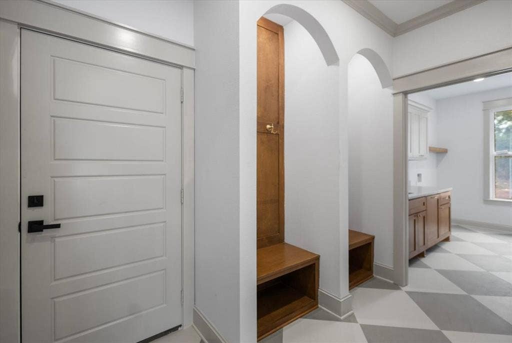 17155 Island Lake Dr., Tyler, TX 75708 Built-in wood-finish bench with storage, arched entryway, matte black door hardware, and checkerboard floor tiling