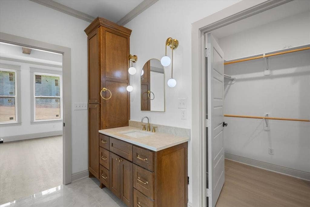 17155 Island Lake Dr., Tyler, TX 75708 Vanity with a single basin, gold-finish faucet, and coordinating wall-mounted light fixtures