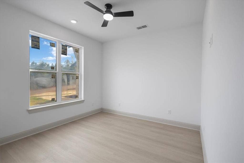 17155 Island Lake Dr., Tyler, TX 75708 Recessed lighting, ceiling fan with integrated light, wood-finish flooring, and a large window with white trim