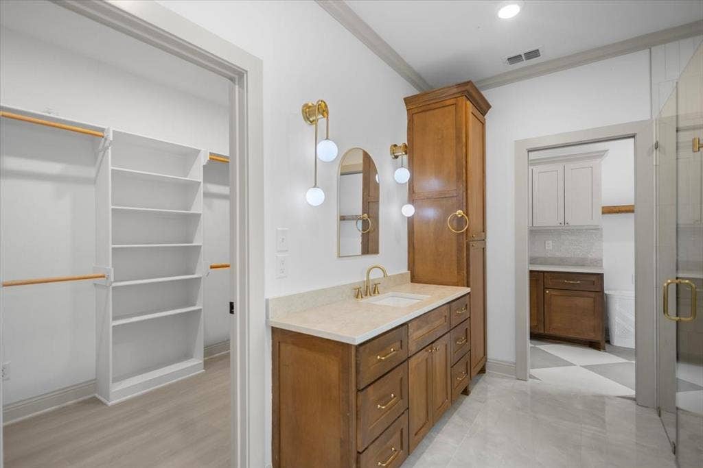 17155 Island Lake Dr., Tyler, TX 75708 Wood-finish vanity with dual sinks, gold-tone hardware, and a light-toned countertop