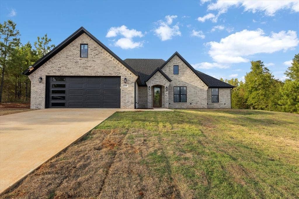 17155 Island Lake Dr., Tyler, TX 75708 Light-colored brick exterior with dark trim and a dark roof