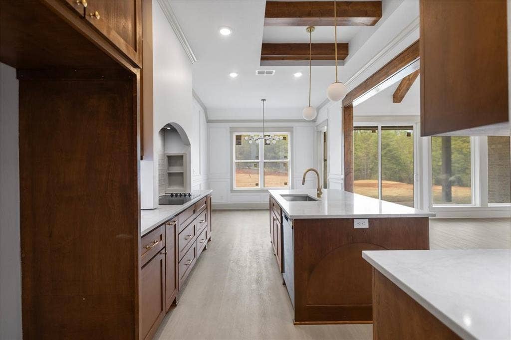 17155 Island Lake Dr., Tyler, TX 75708 Kitchen featuring wood-finish cabinetry, white countertops, a central island with an undermount sink, and recessed lighting