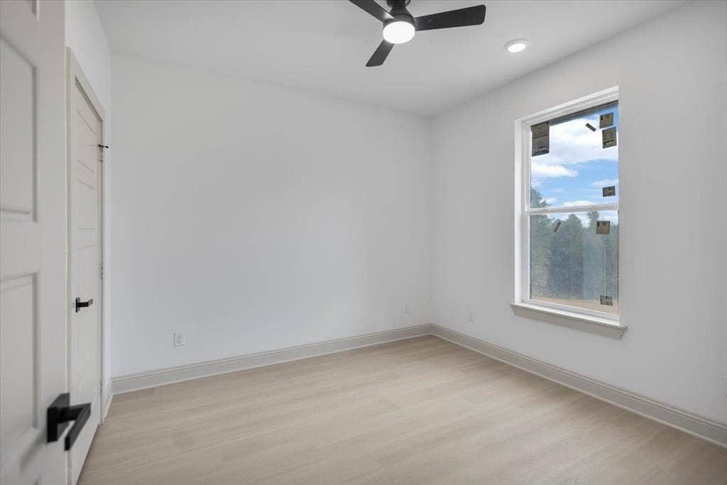 17155 Island Lake Dr., Tyler, TX 75708 Light-toned wood-finish flooring, white walls, ceiling fan with integrated lighting, recessed lighting, and a single window