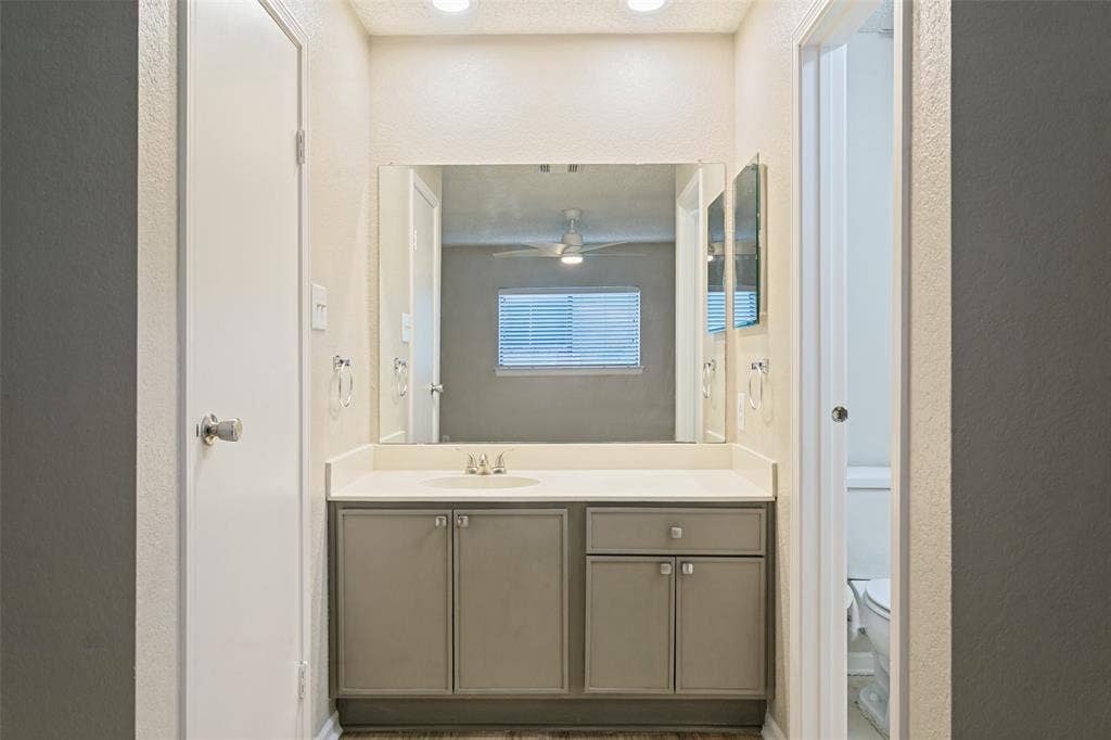 204 Timber Ridge Lane, Coppell, TX 75019 Vanity with a single basin, light-toned countertop, and storage cabinetry