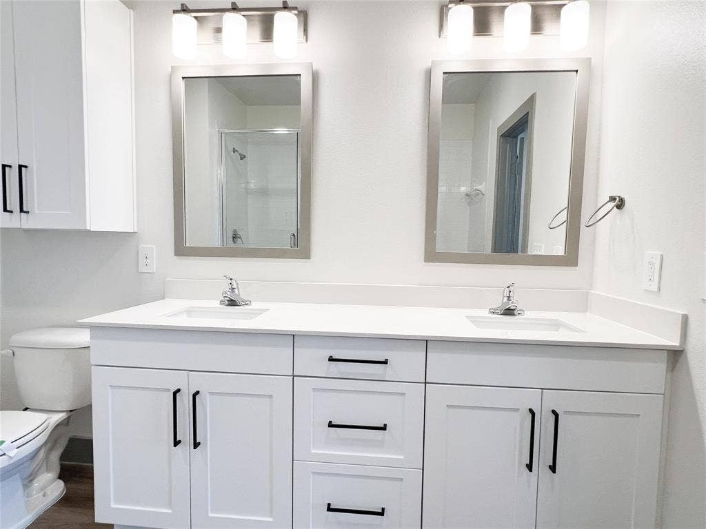 4020 McEwen Road, #8115, Farmers Branch, TX 75244 Bathroom with double vanity, a shower stall, and dark wood-style floors