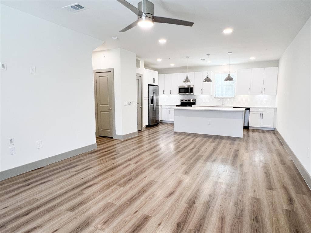 4020 McEwen Road, #8115, Farmers Branch, TX 75244 Kitchen with open floor plan, pendant lighting, a center island, white cabinets, and light countertops