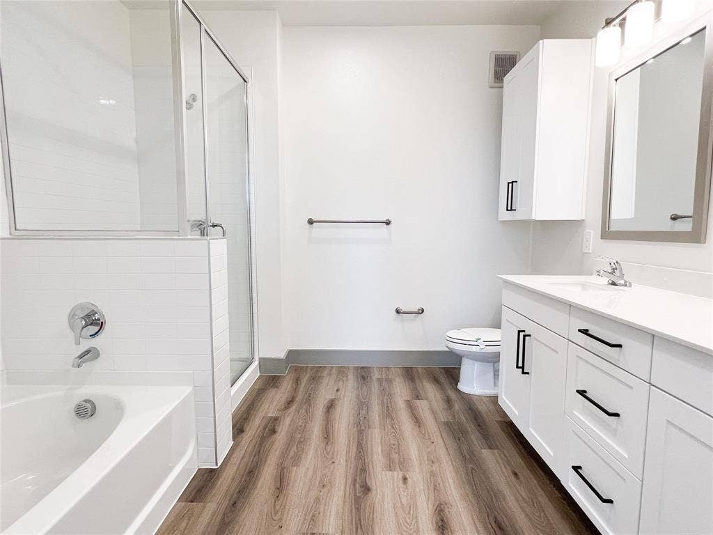 4020 McEwen Road, #8115, Farmers Branch, TX 75244 Full bath featuring a bath, vanity, a stall shower, and light wood-style floors