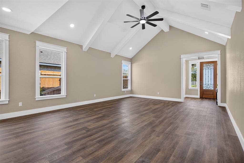 Vaulted ceilings with exposed beams, wood-finish flooring, recessed lighting, ceiling fan, and entry door with decorative glass insert