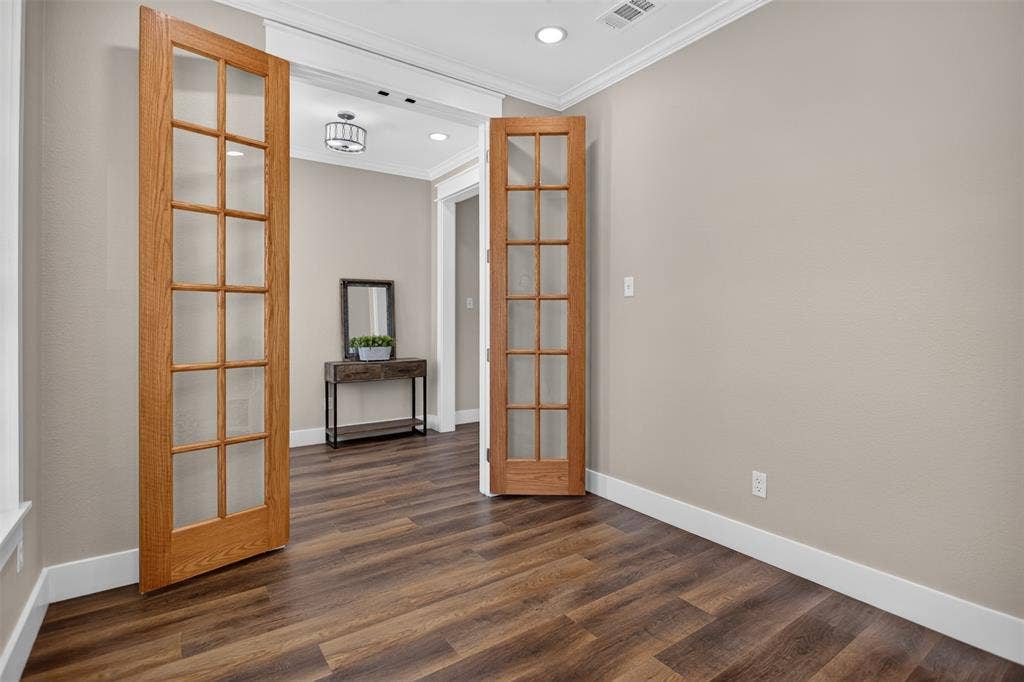 Wood-finish flooring, double glass-paneled interior doors with wood trim, recessed lighting, and crown molding in the office or potential fourth bedroom.