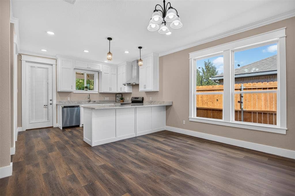 Kitchen featuring white cabinetry, granite finish countertops, stainless steel appliances, pendant lighting, and wood-finish flooring