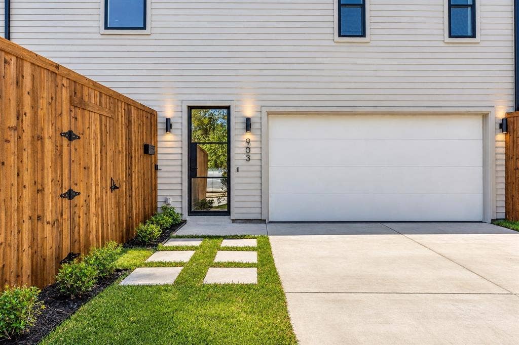 903 Bayonne Street, Dallas, TX 75212 Horizontal siding, black-framed entry door, front yard landscaping, concrete driveway, and attached garage