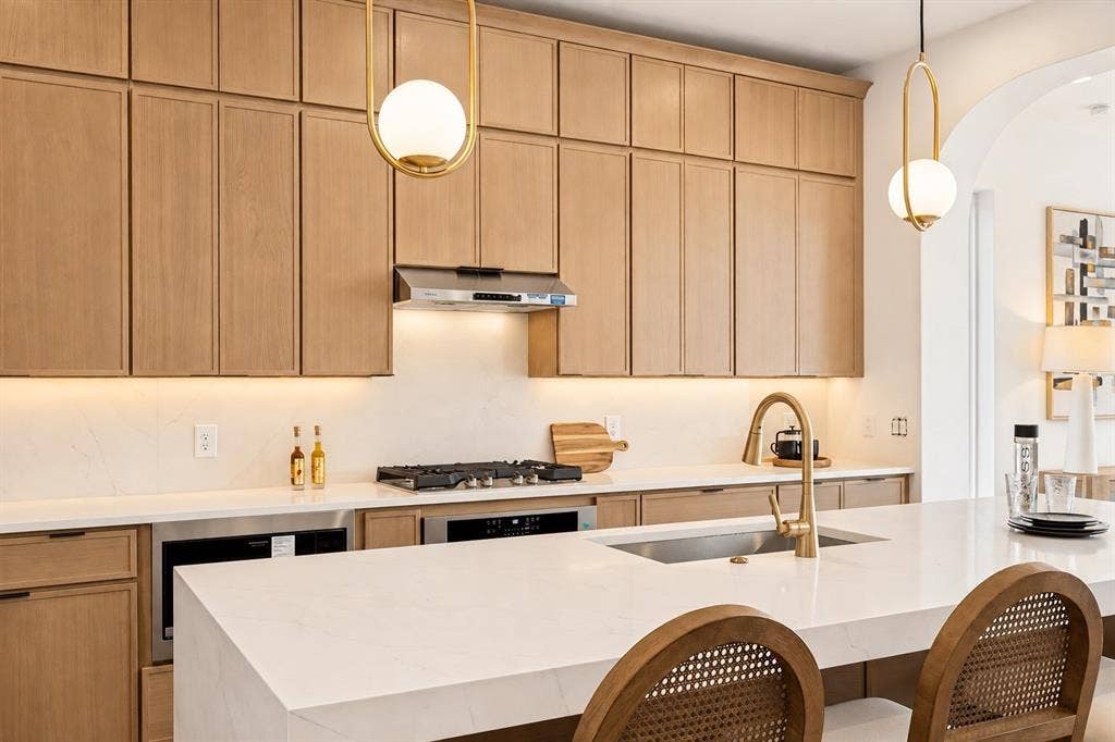903 Bayonne Street, Dallas, TX 75212 Wood-finish cabinetry with full overlay doors, integrated stainless steel appliances, and a gas cooktop