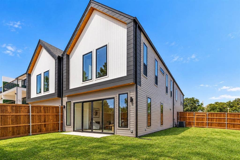 903 Bayonne Street, Dallas, TX 75212 Contemporary architecture featuring a peaked roofline, vertical white siding, gray horizontal siding, and multiple large windows