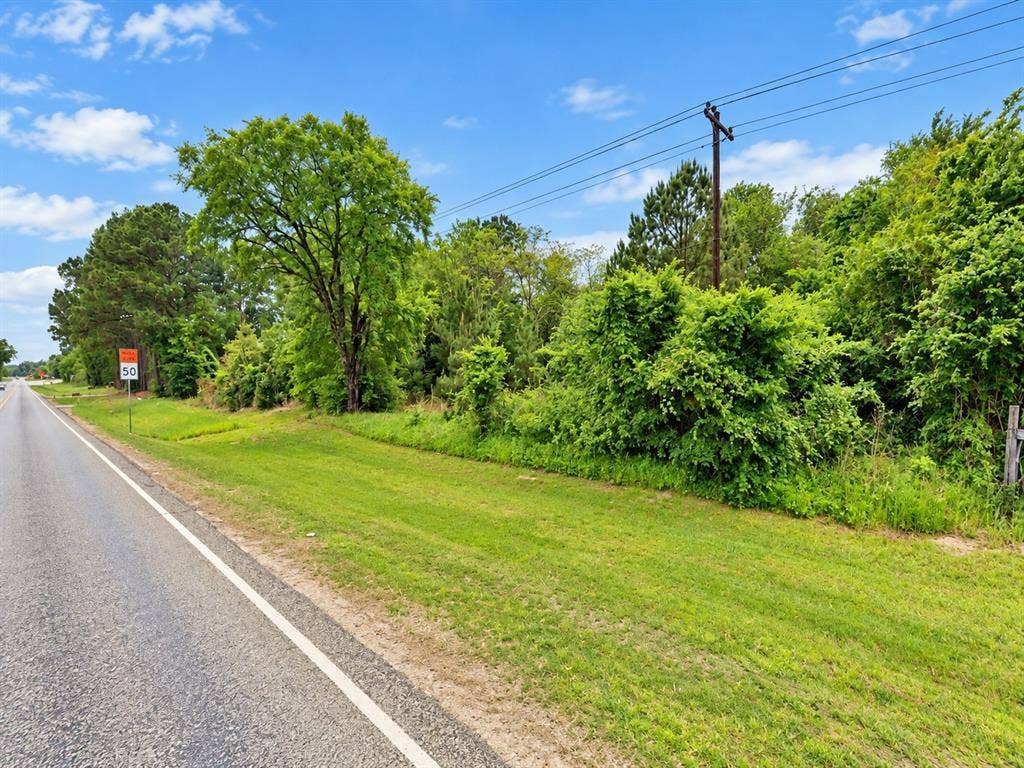TBD ST HWY 198, Mabank, TX 75156 Expansive roadside parcel featuring mature trees, lush green foliage, and natural landscaping