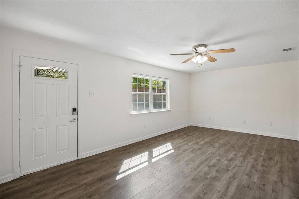 2245 County Road 337, McKinney, TX 75071 Wood-finish flooring, white entry door with decorative glass inlay, multi-pane window, and ceiling-mounted light fixture with fan