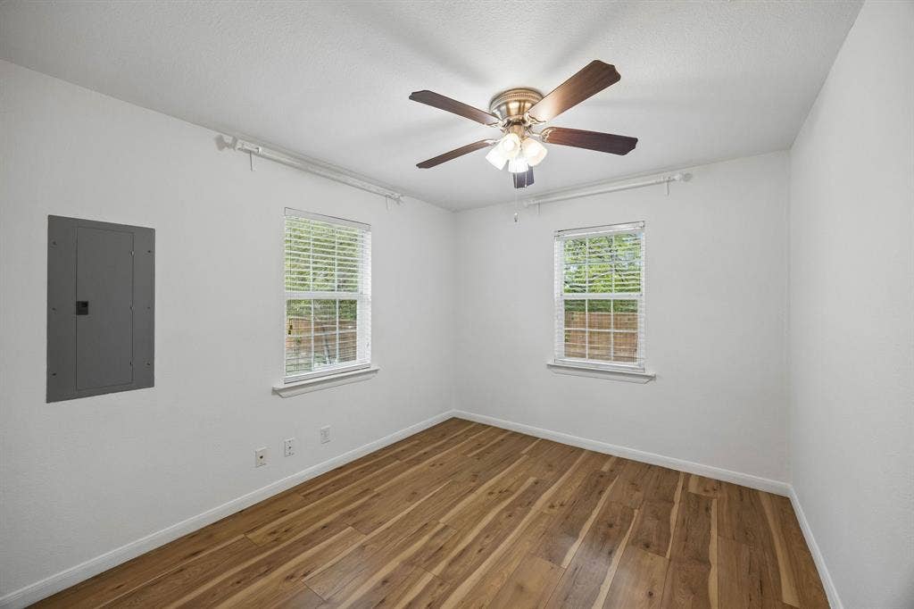 2245 County Road 337, McKinney, TX 75071 Room featuring wood-finish flooring, two windows with blinds, and a ceiling fan with integrated lighting