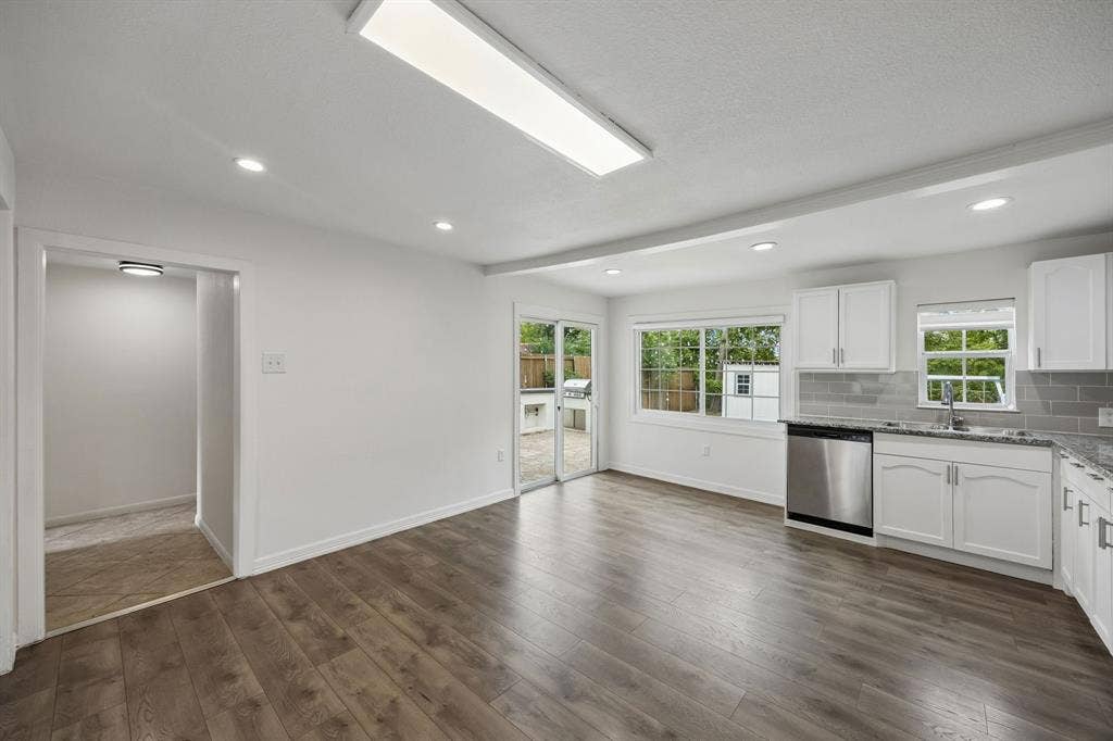 2245 County Road 337, McKinney, TX 75071 Kitchen featuring wood-finish flooring, white cabinetry, stone-finish countertops, subway tile backsplash, and stainless steel dishwasher
