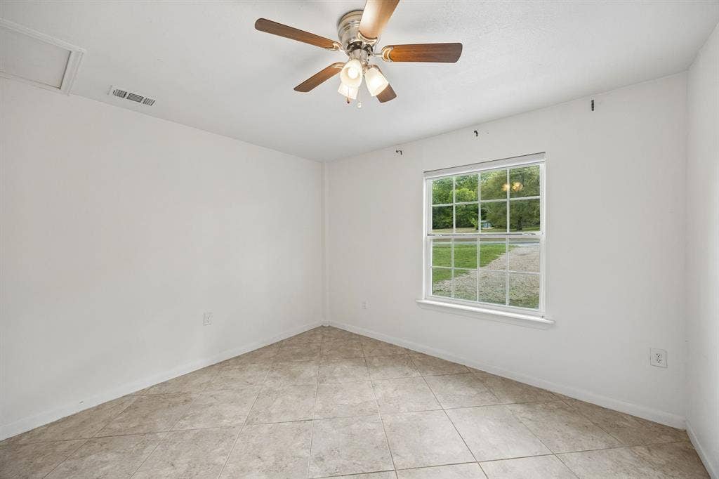 2245 County Road 337, McKinney, TX 75071 Neutral wall finishes, grid-patterned window, ceiling fan with integrated lighting, and diagonal-set tile flooring