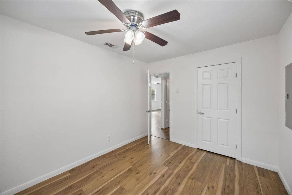 2245 County Road 337, McKinney, TX 75071 Interior room featuring wood-finish flooring, a six-panel interior door, and a ceiling fan with integrated light fixtures