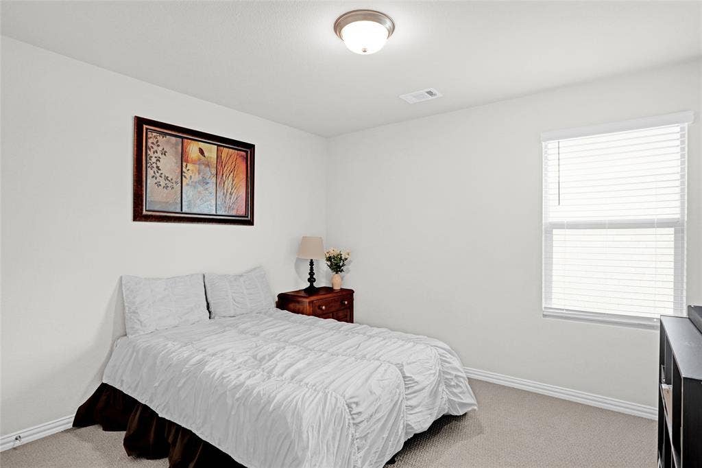 Bedroom featuring light colored carpet and baseboards