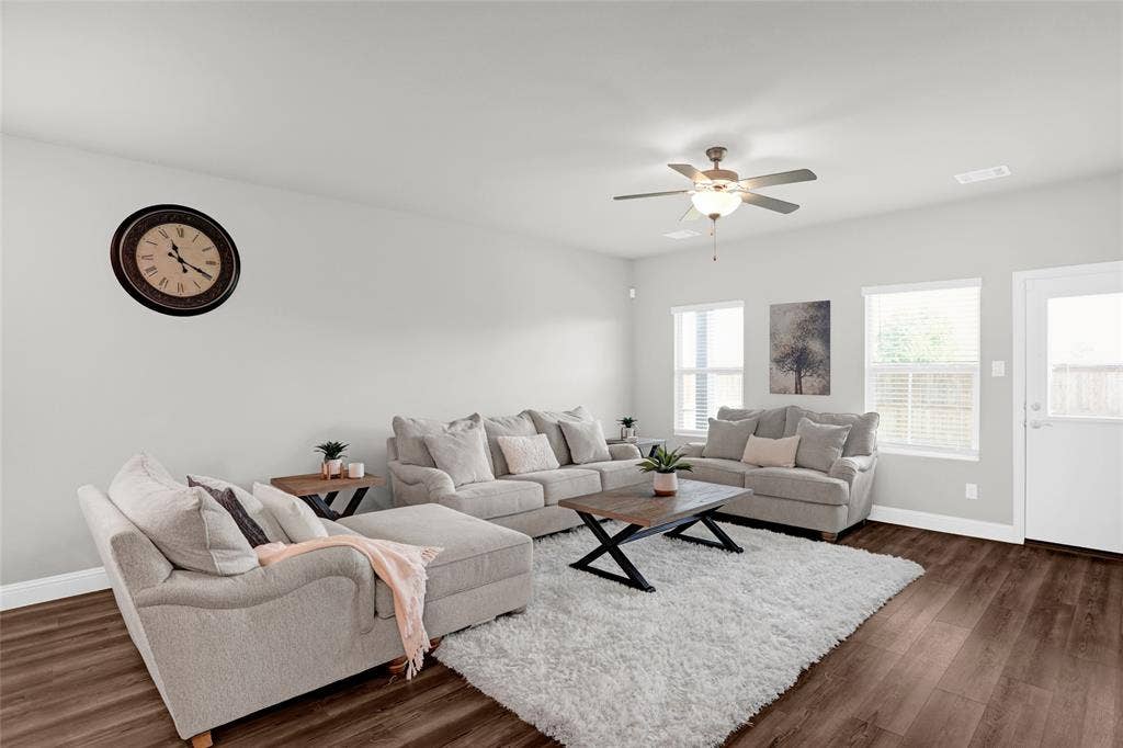 Living area featuring dark wood-style floors and a ceiling fan