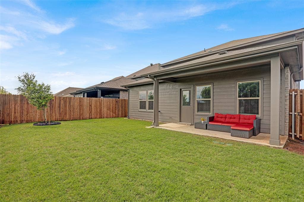 Back of property featuring a fenced backyard, outdoor lounge area, and a patio
