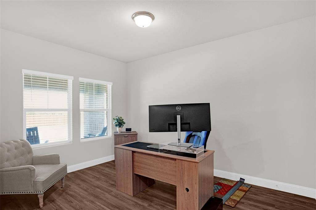 Home office with baseboards and wood finished floors