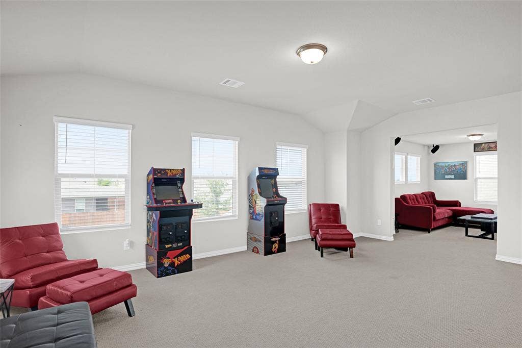 Sitting room with vaulted ceiling and light carpet