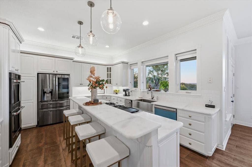 2945 Emerald Sound Drive, Cedar Hill, TX 75104 Kitchen featuring white cabinetry, stone-surface countertops, stainless steel appliances, farmhouse sink, and glass pendant lighting