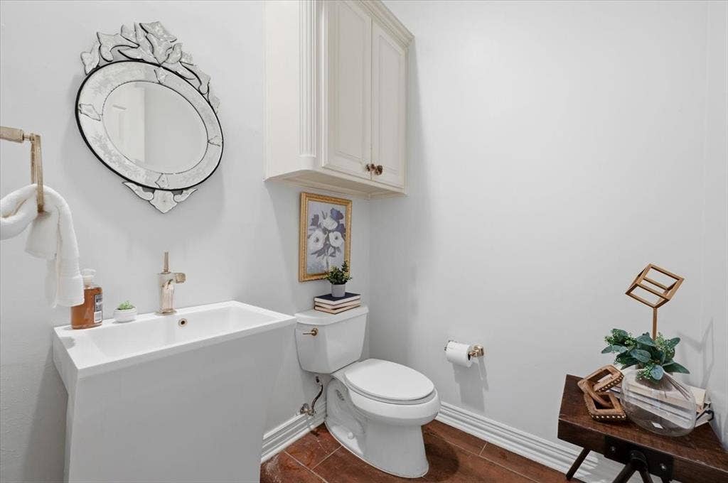 2945 Emerald Sound Drive, Cedar Hill, TX 75104 Wall-mounted cabinetry, pedestal sink with a metallic faucet, ornate wall mirror, and tile flooring