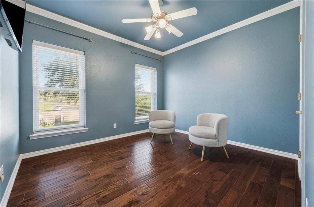 2945 Emerald Sound Drive, Cedar Hill, TX 75104 Room featuring wood-finish flooring, dual windows, crown molding, and a central ceiling fan with integrated lighting
