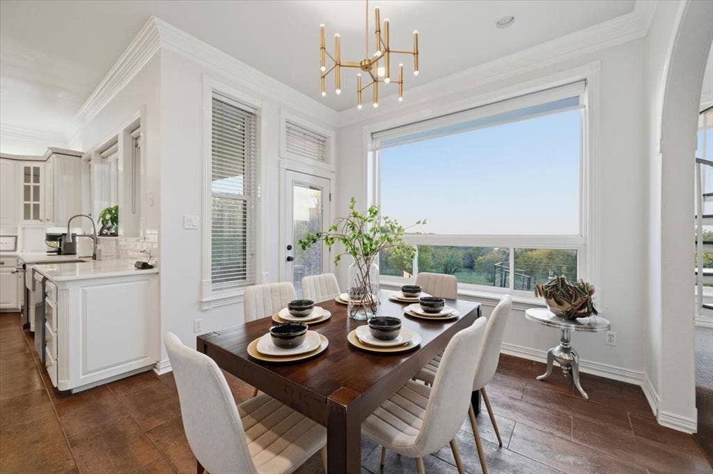2945 Emerald Sound Drive, Cedar Hill, TX 75104 Dining area featuring wood-finish flooring, a contemporary multi-arm brass chandelier, crown molding, and a large picture window