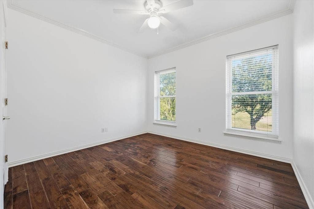 2945 Emerald Sound Drive, Cedar Hill, TX 75104 Room featuring wood-finish flooring, dual windows, crown molding, and a central ceiling fan with an integrated light fixture