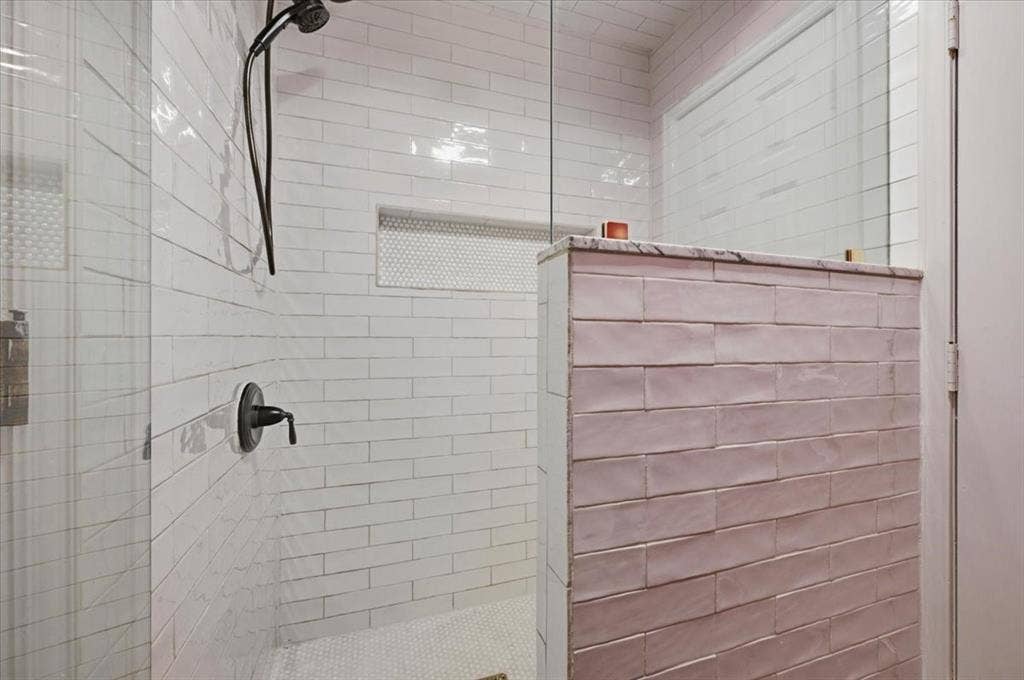 2945 Emerald Sound Drive, Cedar Hill, TX 75104 Walk-in shower featuring subway tile wall finishes, a built-in recessed niche, a glass partition, and a matte black shower fixture