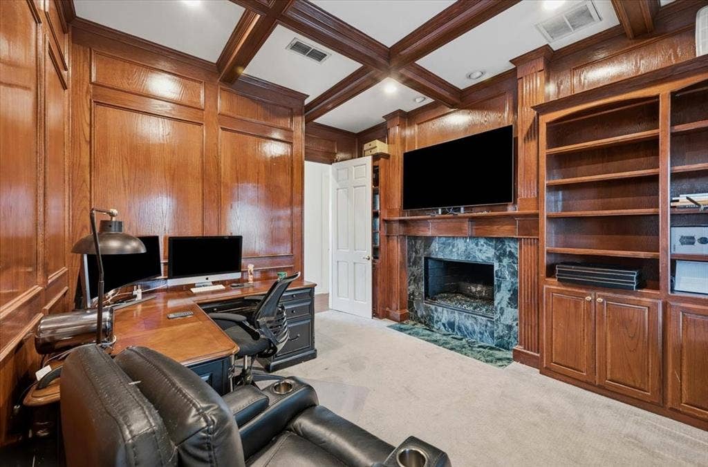 2945 Emerald Sound Drive, Cedar Hill, TX 75104 Rich wood-paneled walls and ceiling coffering, custom built-in floor-to-ceiling cabinetry, and a fireplace with a stone surround