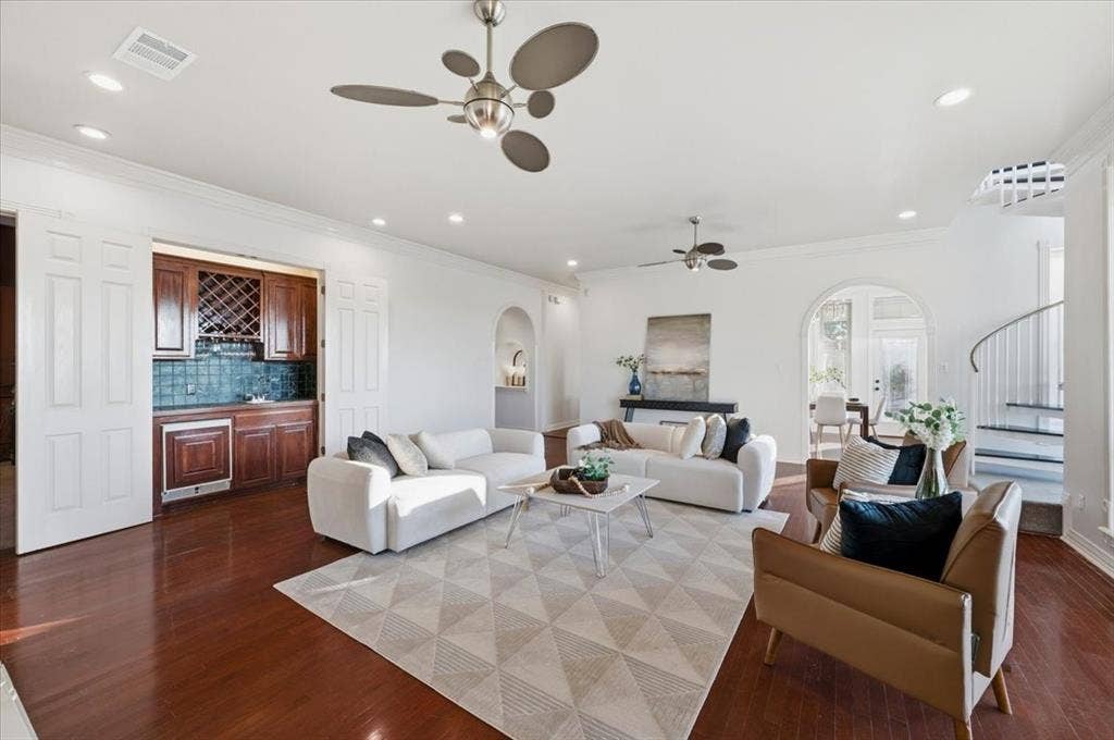 2945 Emerald Sound Drive, Cedar Hill, TX 75104 Living area featuring wood-finish flooring, recessed lighting, built-in cabinetry with integrated wine storage, arched doorways, and a spiral staircase