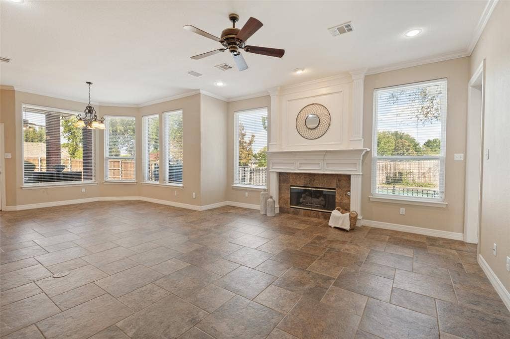 2704 Horsehead Crossing, Southlake, TX 76092 Open concept living space featuring stone-style tile flooring, multi-pane windows, a fireplace with decorative millwork mantel, and recessed lighting