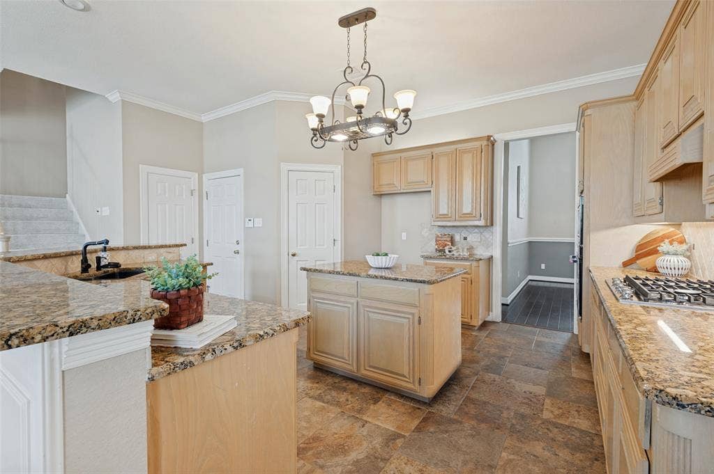 2704 Horsehead Crossing, Southlake, TX 76092 Kitchen featuring light wood cabinetry, stone-surface countertops, central island, decorative iron chandelier, and tile flooring