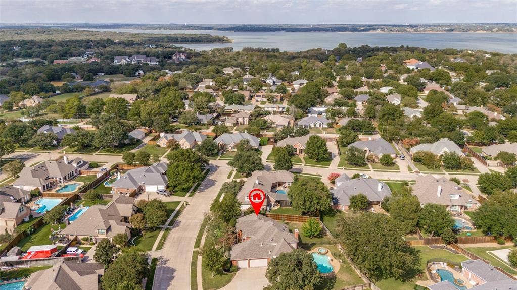2704 Horsehead Crossing, Southlake, TX 76092 Aerial perspective of residential property featuring a multi-gable roofline, attached two-car garage, private swimming pool, and mature perimeter trees